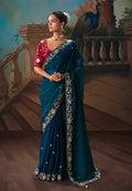Teal blue fancy fabric saree featuring elegant embroidered detailing