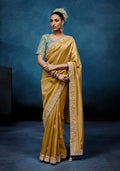 Gold fancy fabric saree with intricate embroidery and matching stitched blouse