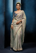 A graceful light grey fancy fabric saree featuring detailed embroidery and khatli work with a stitched blouse.