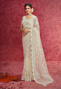 Elegant off white net saree with sequins, zari, and thread embroidery on a scalloped border