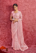 Pink net saree featuring sequins and zari embroidery with scalloped lace border