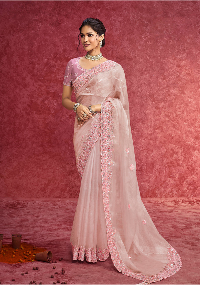 Baby girl wearing an elegant baby pink faux tissue embroidered saree with sequin detailing and a scalloped border.