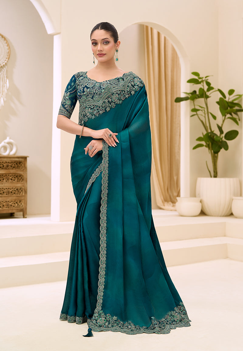 Teal faux chiffon saree with decorative satin border and embroidery.