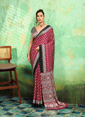 A close-up view of the maroon faux satin fabric featuring traditional Ajrakh prints on a saree.