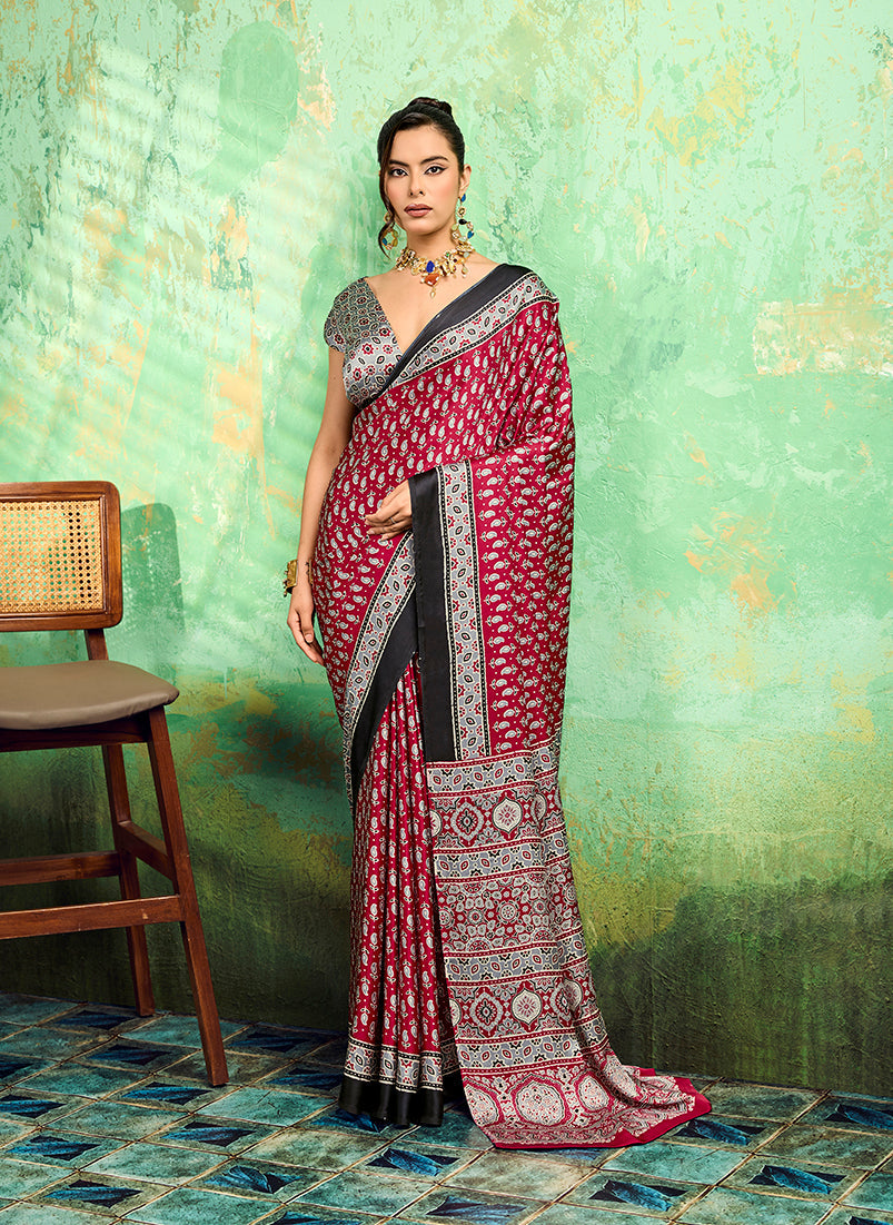 A close-up view of the maroon faux satin fabric featuring traditional Ajrakh prints on a saree.