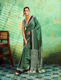 Green saree with traditional Ajrakh prints and a smooth faux satin finish.