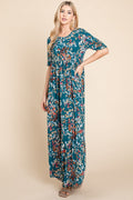 Flowing teal and multicolor abstract shirred maxi dress with a bohemian aesthetic.