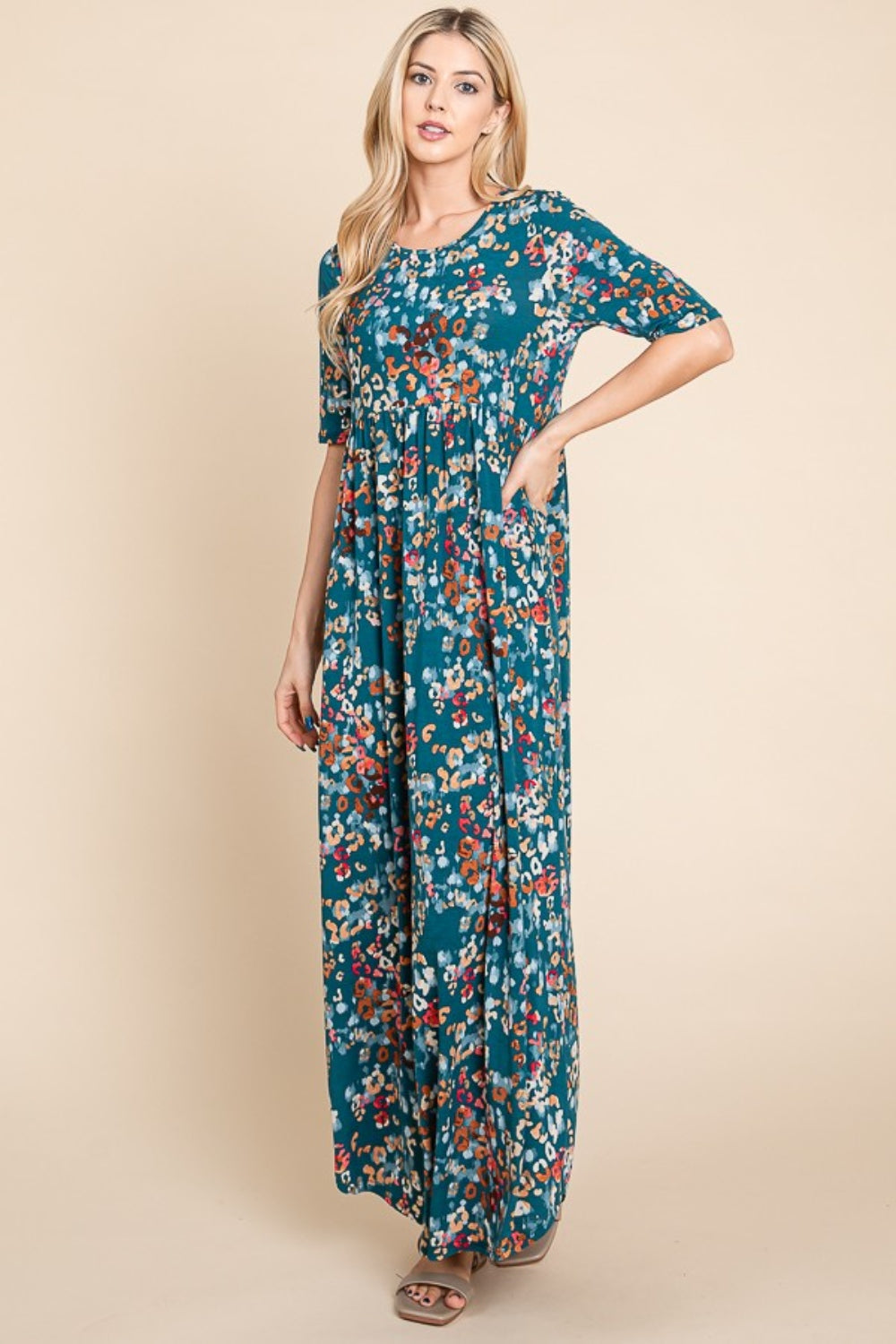 Flowing teal and multicolor abstract shirred maxi dress with a bohemian aesthetic.