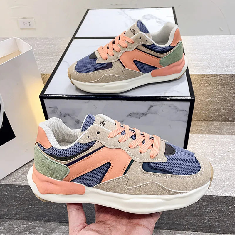 Pair of Harajuku Style women's multicolor lightweight running shoes with blue, peach, green, and beige panels on a white chunky sole, displayed on a marble surface.