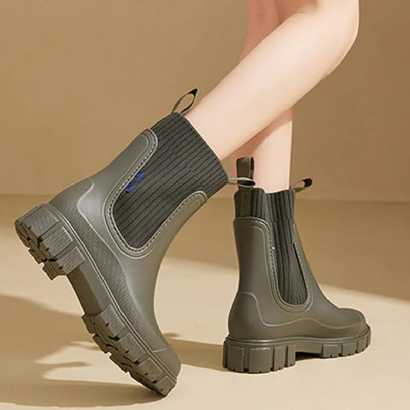 Women wearing olive and cream colored mid-tube waterproof rain boots with lug soles