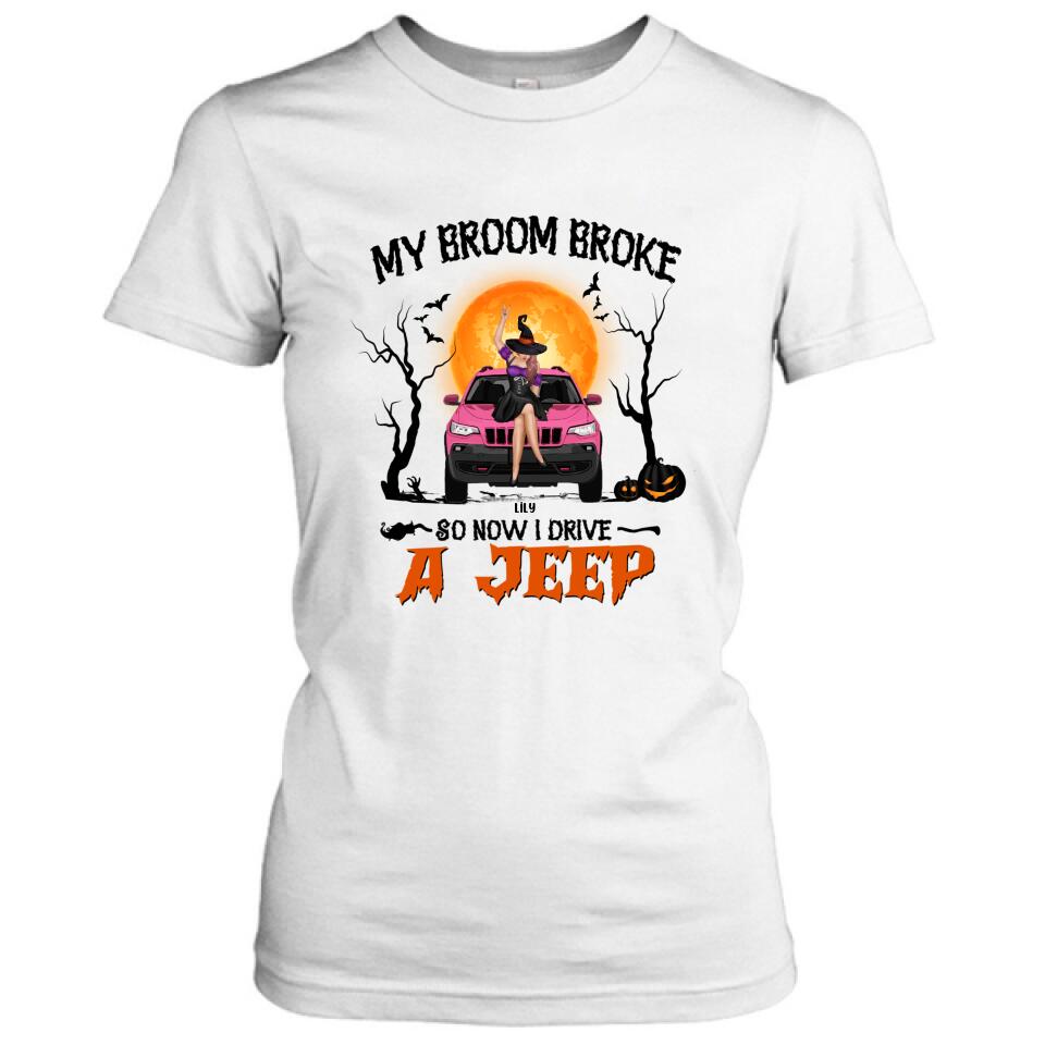 A white t-shirt featuring a graphic of a witch driving a pink Jeep with the text My broom broke so now I drive a Jeep