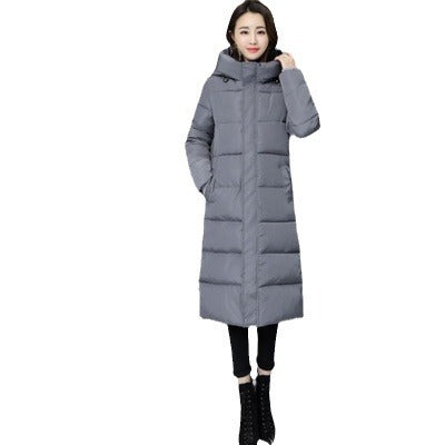 A woman wearing a long grey hooded puffer parka with black leggings and boots. Another image shows a woman wearing a long black hooded puffer parka.