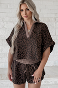 Woman wearing a brown leopard print two-piece set with a V-neck collared top and matching relaxed shorts.