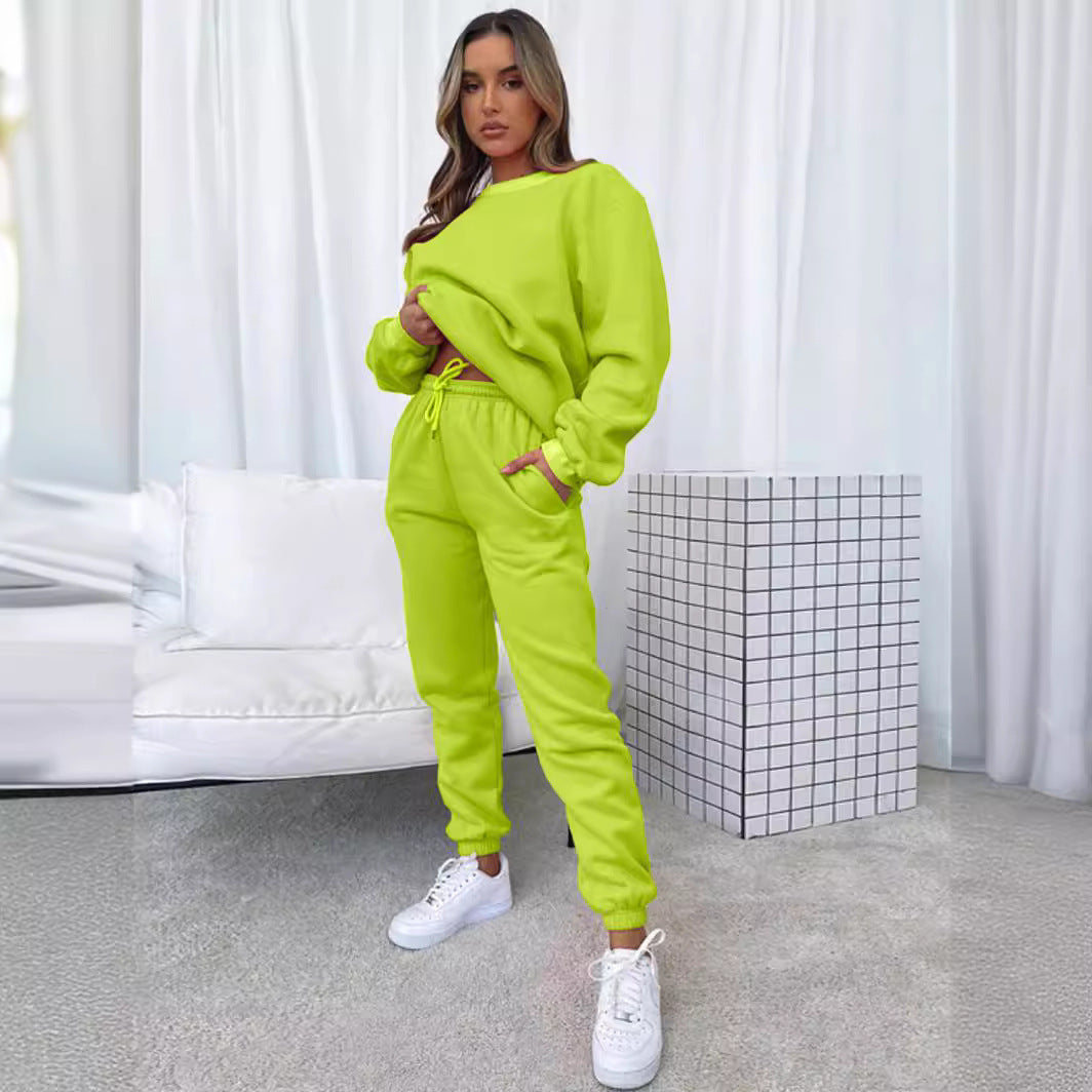 Model wearing a matching solid color round neck pullover sweatshirt and jogger pants set