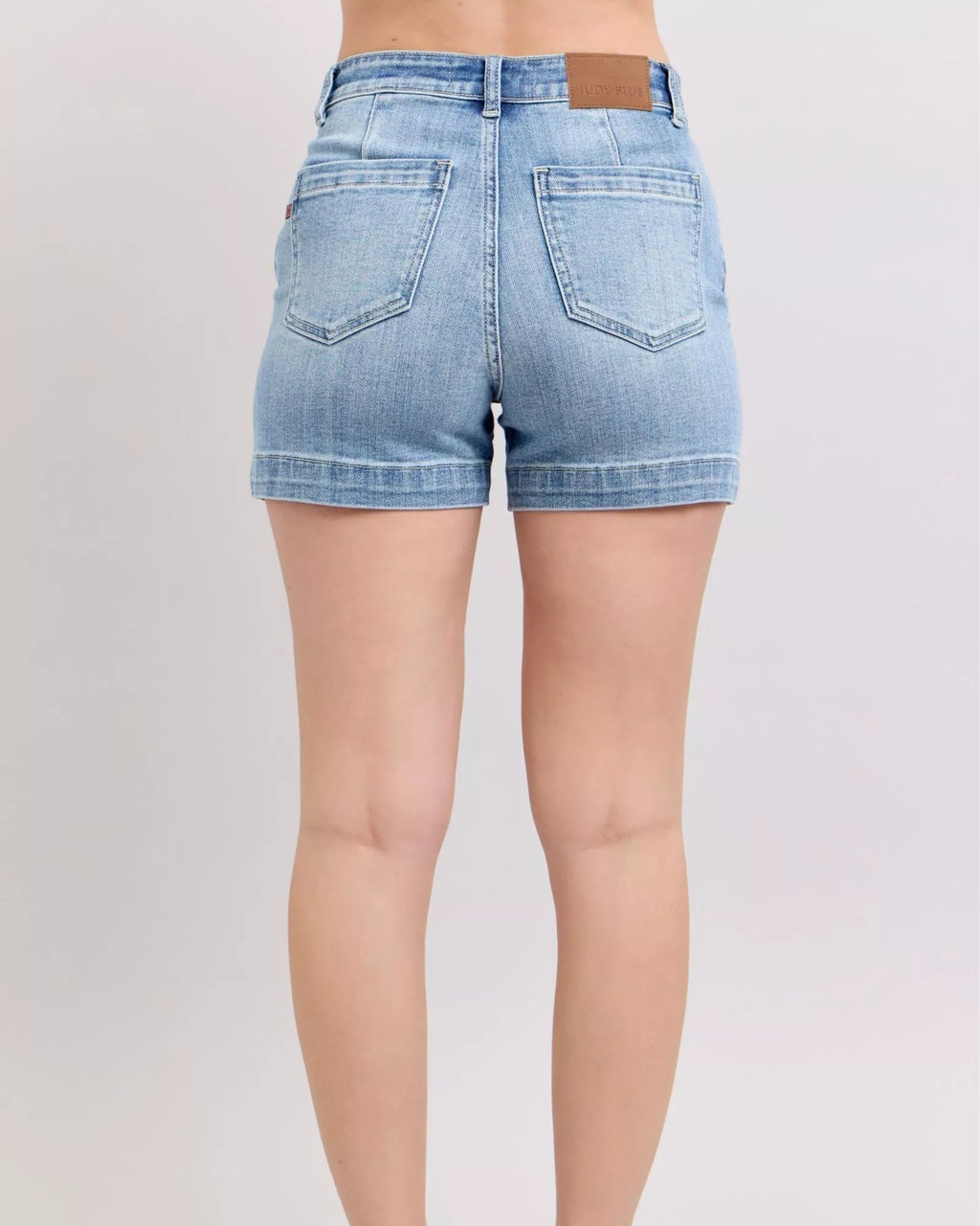 Light blue denim shorts worn by a person on a plain background