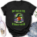 A black t-shirt featuring a witch graphic with the text Don't Make Me Stick My Broom Up Your Ass in green lettering.
