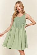 A sage-green sleeveless babydoll dress with decorative front buttons