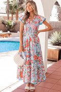 Woman wearing a floral print Nina flutter sleeve long dress with a tiered skirt and V-neckline