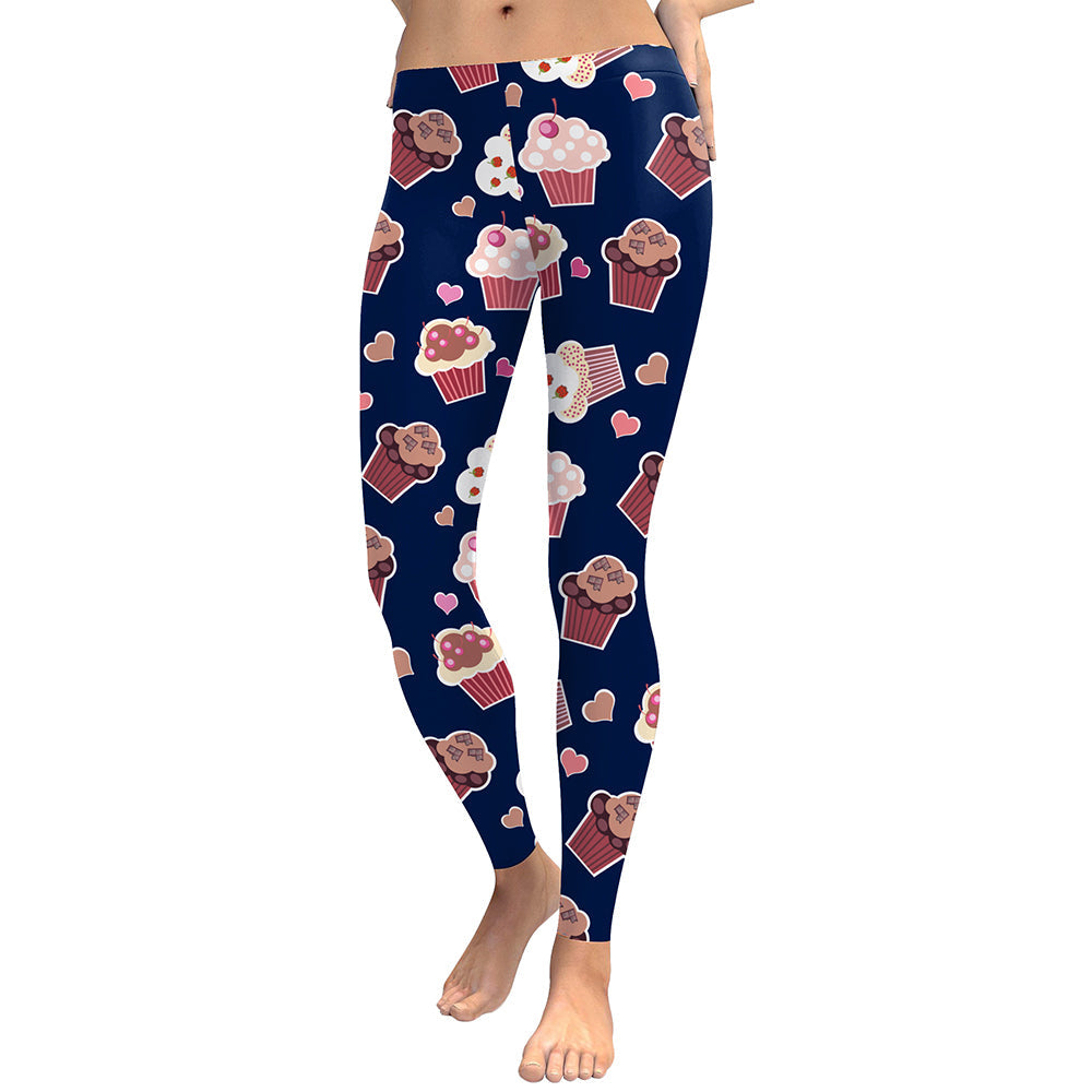 Women's navy blue full-length leggings featuring a playful digital print of various pink, white, and brown cupcakes with small red hearts.