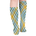 Pair of yellow plaid knee-high socks, featuring blue, green, and purple accents, on a white background, highlighting its breathable and comfortable features.