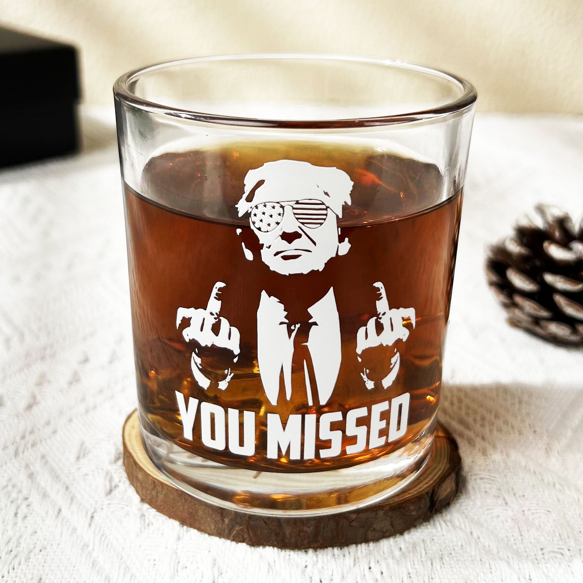 Clear whiskey glass featuring white You Missed Trump graphic and signature on the bottom.