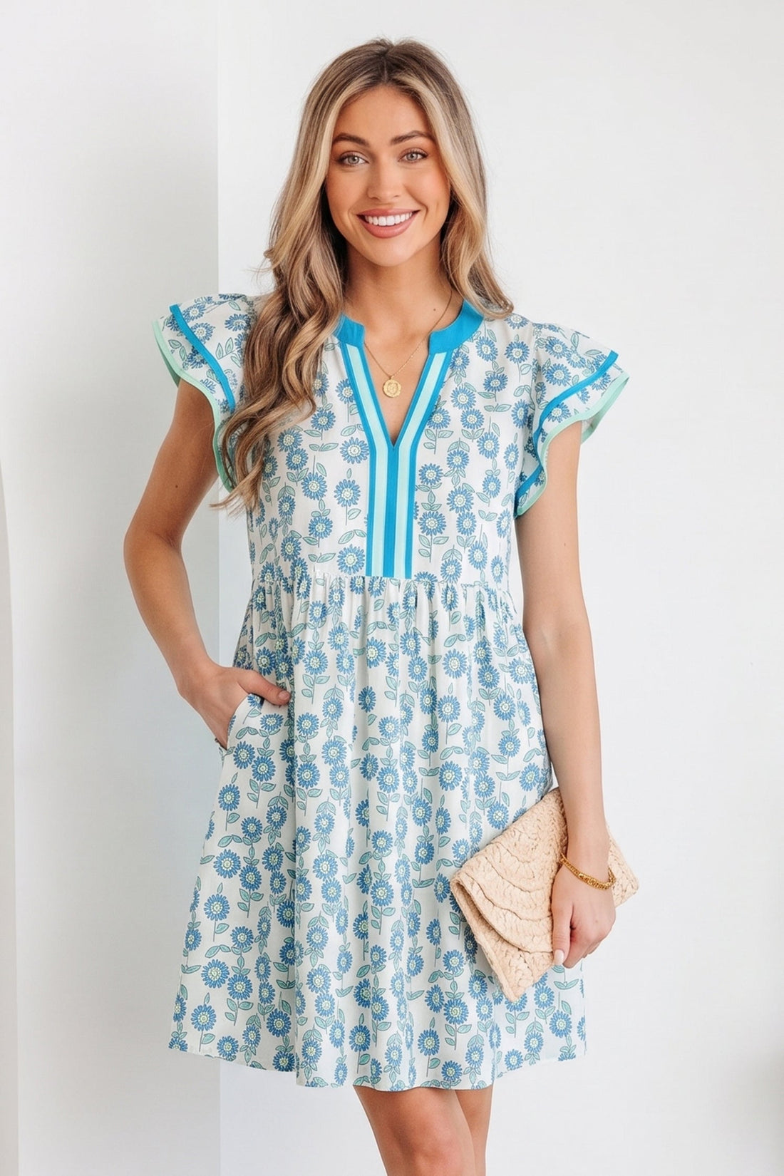 Marlowe mini dress featuring floral print, flutter sleeves, and v-neckline in white and blue cotton-blend fabric.