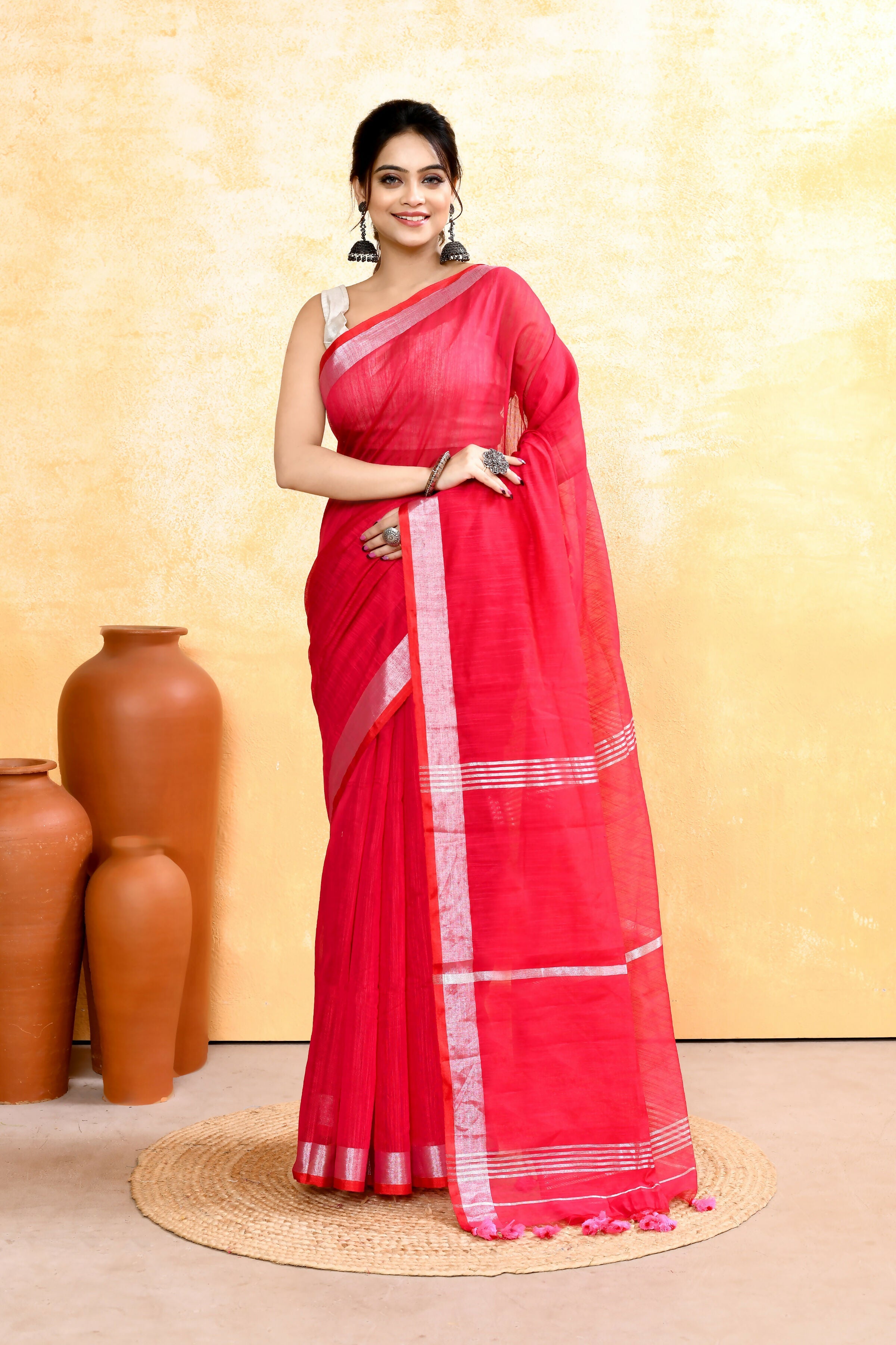 Rani pink handloom saree with zari border and embellishments draped elegantly.