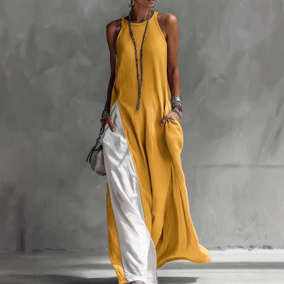 A woman wearing a sleeveless, loose-fitting maxi dress featuring a colorblock design with side pockets.