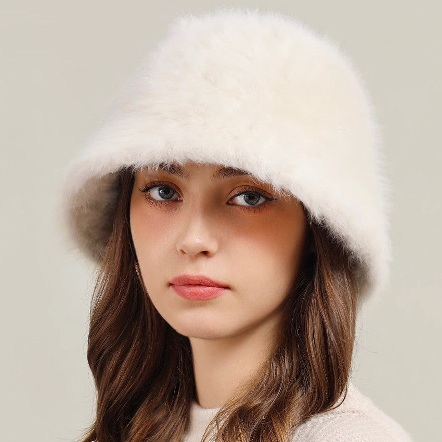 A woman wearing a white real rabbit plush bucket hat, showing the soft texture and comfortable fit.