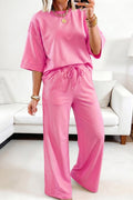 A Sachet Pink two-piece set featuring a half-sleeve top with lace patchwork details and matching pants with an elastic waistband.