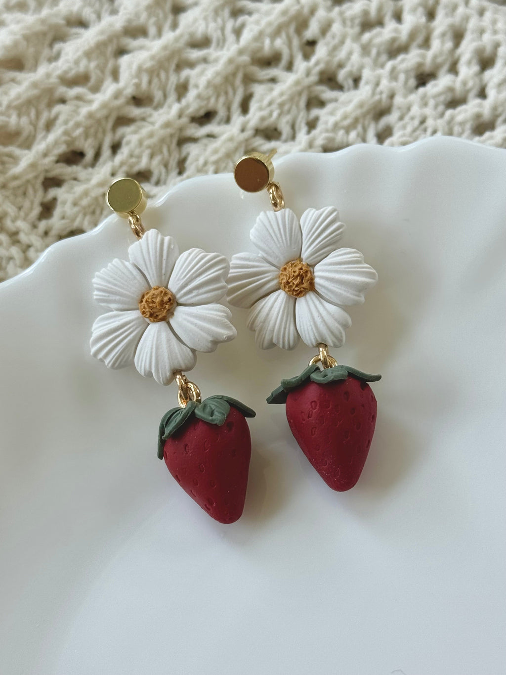 Bloom and Berry handmade polymer clay earrings with red and green floral motifs on gold hooks.