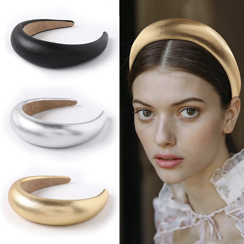 A set of three wide padded headbands in metallic gold, silver, and black, with one worn by a model, showcasing a chic and comfortable hair accessory.