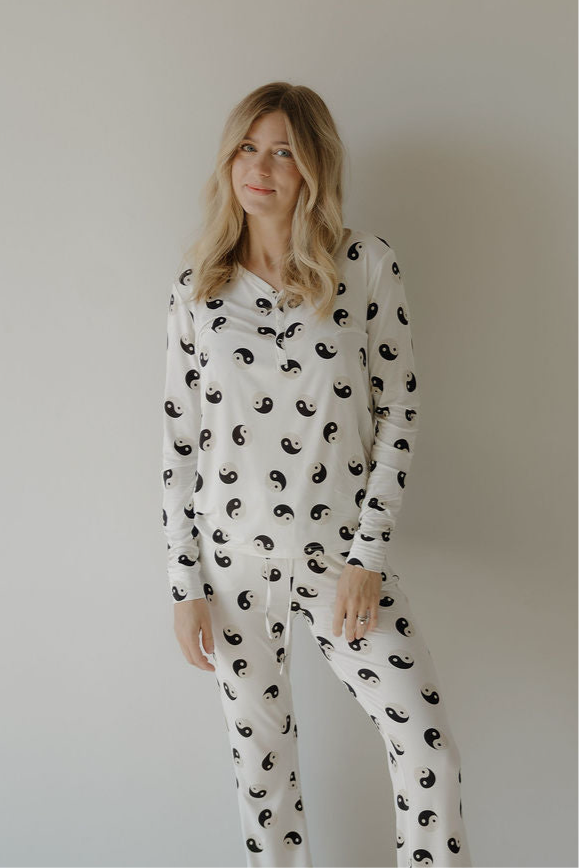 A woman wearing a long-sleeve bamboo pajama set with a black and white Yin Yang print.