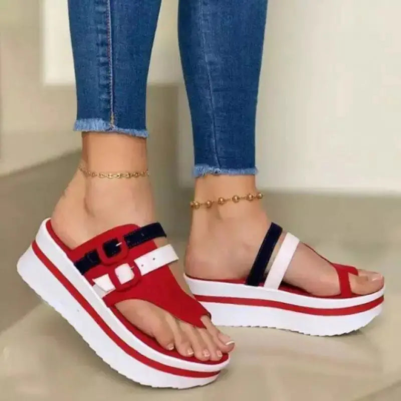 Women's red, white, and blue wedge platform thong sandals worn with jeans