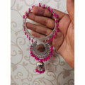 Silver-tone bangle adorned with pink pearls and a hanging jhumka charm.
