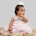 Girl wearing a pink and grey sequin gown with frill hem and floral shoulder detail