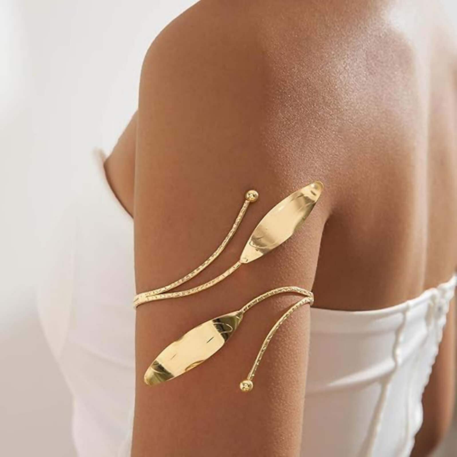 Golden alloy bohemian style kada bajuband armlet for women displayed on a neutral background