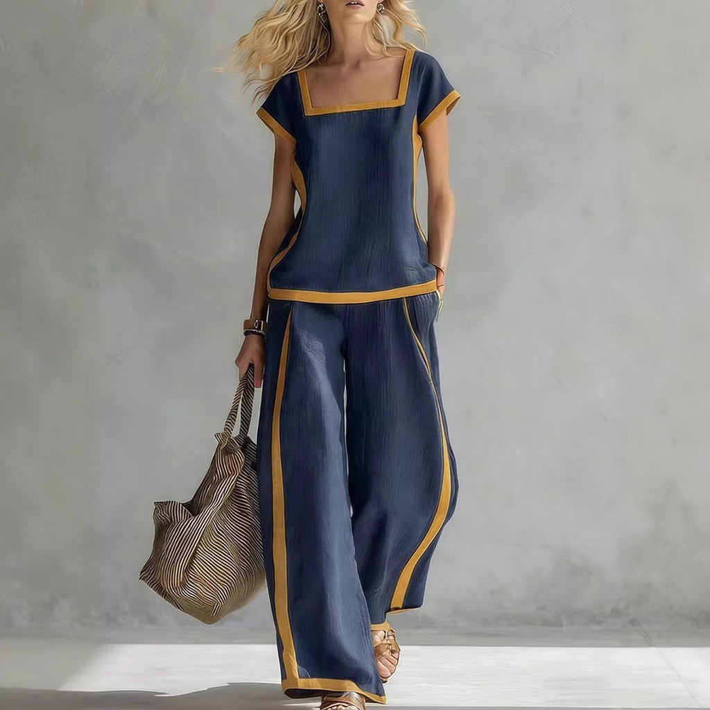 A woman wearing a stylish navy and yellow trim two-piece set with a square neck top and wide-leg pants.