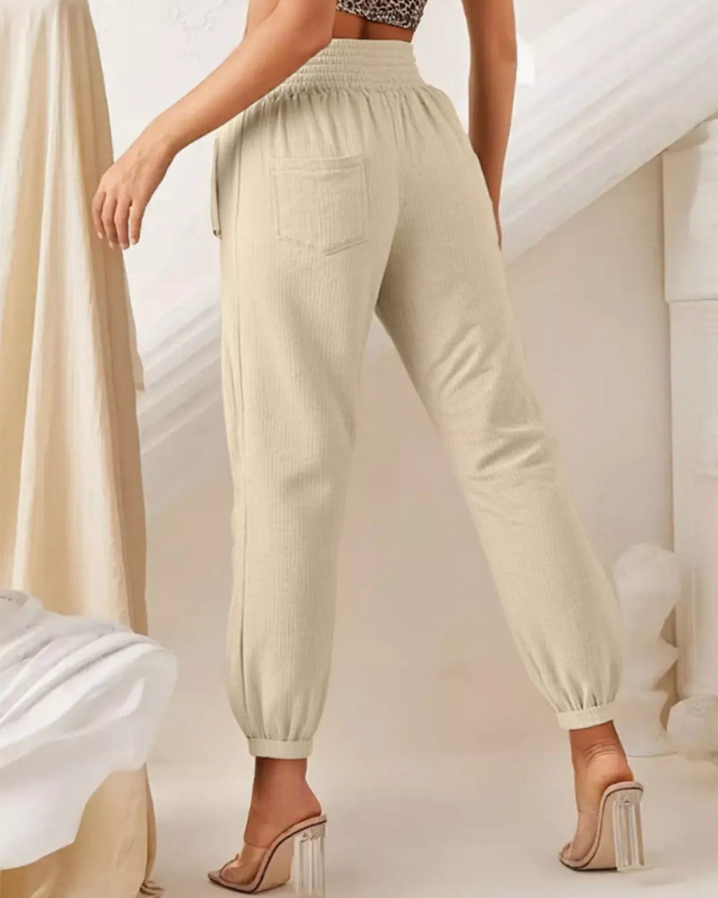 Beige jogger pants worn by a person on a neutral background