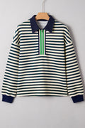 Woman wearing a striped long sleeve top with a zip-up collared neckline and contrast trim.