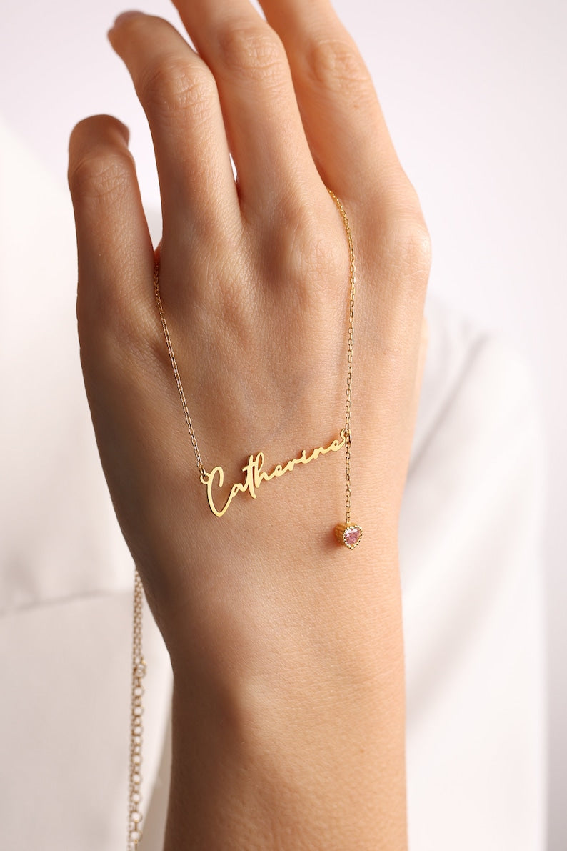 Personalized cursive name necklace with a custom birthstone charm on a delicate gold-toned chain.