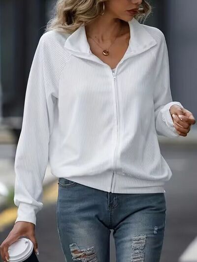 Women wearing a white zip-up collared jacket with raglan sleeves and a casual fit