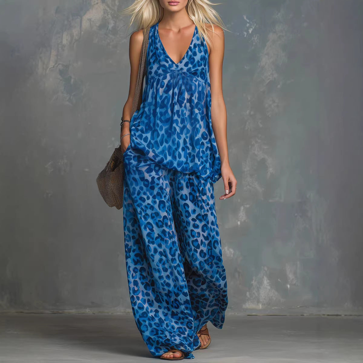 A woman wearing a matching leopard print two-piece set featuring a sleeveless tank top and wide-leg chiffon pants.