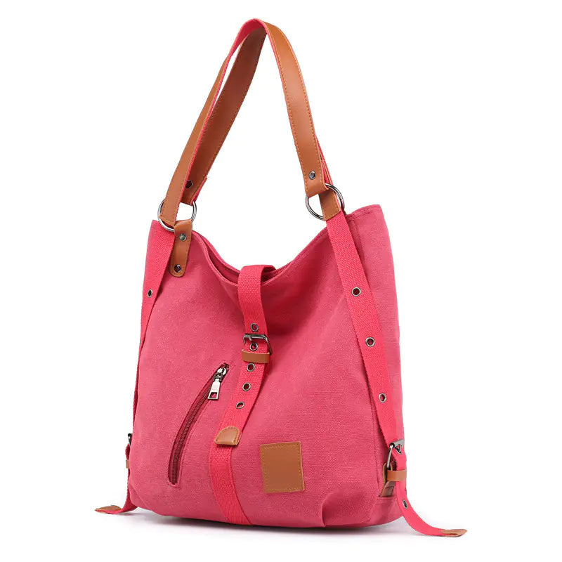 A casual canvas women's shoulder tote bag in pink and brown color options featuring a front buckle strap and zipper detail.