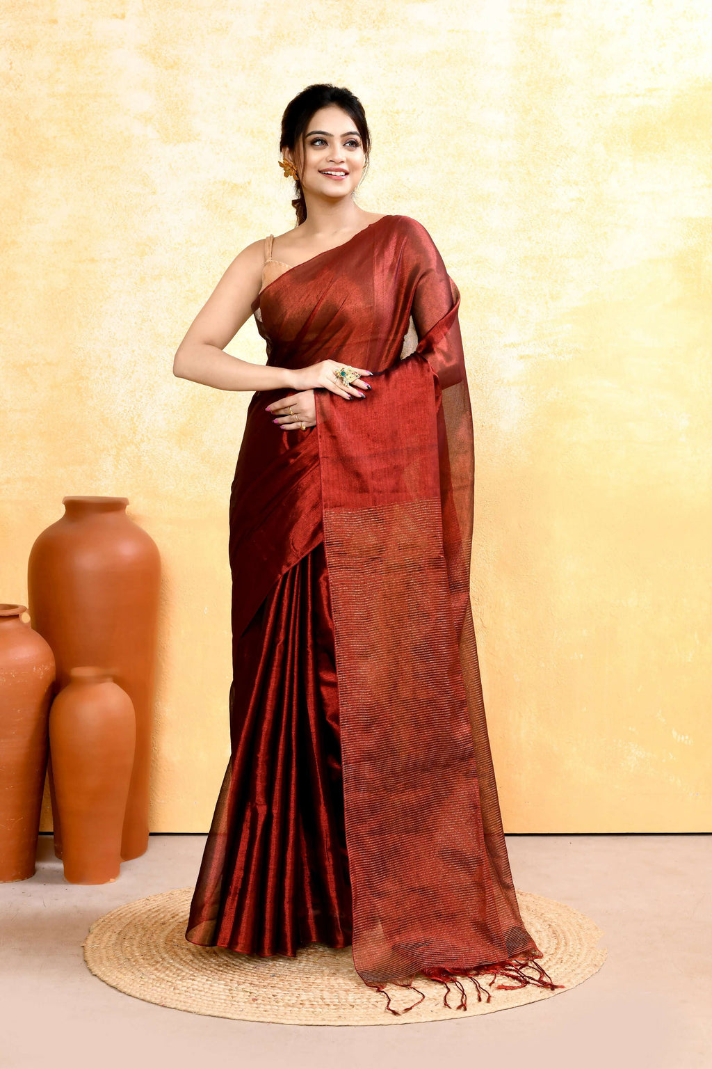 A woman wearing a Maroon Dual Tone Organic Tissue Saree with a matching blouse piece