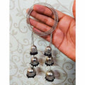Sophisticated silver-tone bangle with black pearl detailing and hanging jhumka ornaments.
