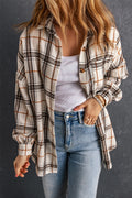 Woman wearing an oversized plaid shacket in off-white, brown, and black with side slits