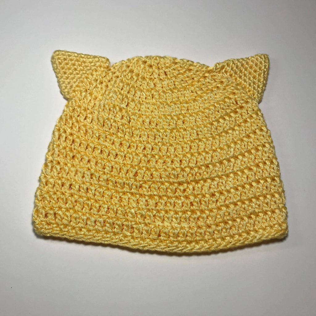 Cute yellow kids beanie with kitten ears, shown as a knitting or crochet DIY pattern project.