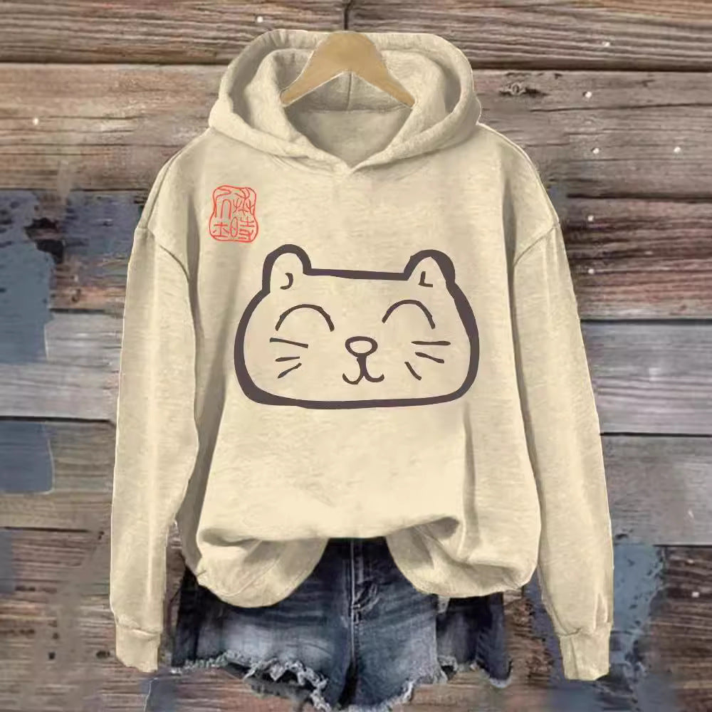 Women's beige hooded sweatshirt with a central cat graphic print on a rustic background