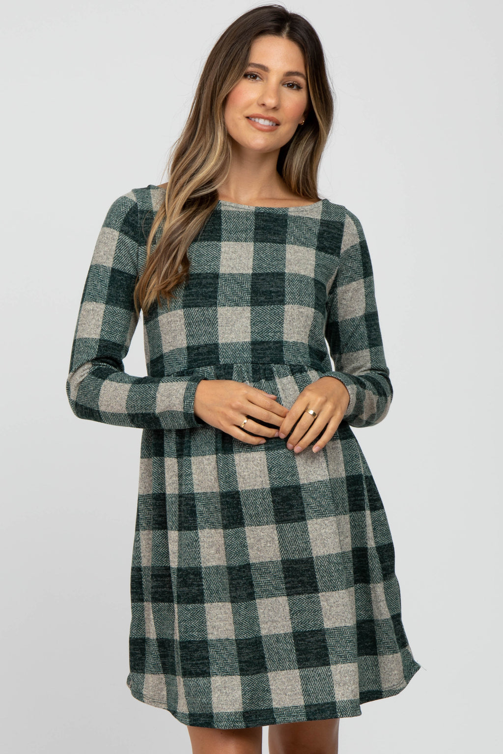 Model wearing a Forest Green Plaid Knit long sleeve maternity dress with a crew neckline.
